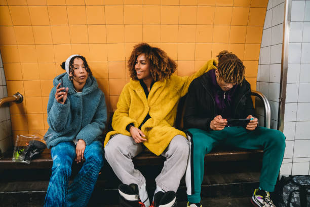 istock Three friends waiting for the train in a subway station 1355054601