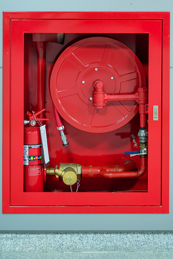 Fire extinguisher and water pump system on the wall background, powerful emergency equipment for industrial and residential
