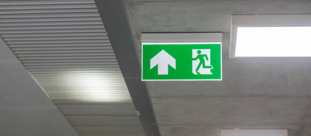 istock Fire Emergency exit sign on the wall inside building at subway train station. Safety concept 1355056302