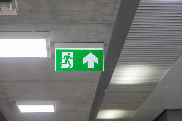 istock Fire Emergency exit sign on the wall inside building at subway train station. Safety concept 1355056312