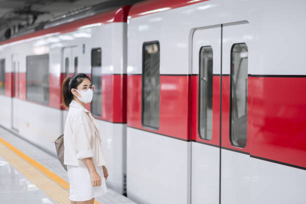 istock woman wearing Protective face mask prevention coronavirus inflection during waiting train. public transportation. social distancing, new normal and safety under covid-19 pandemic 1355056347