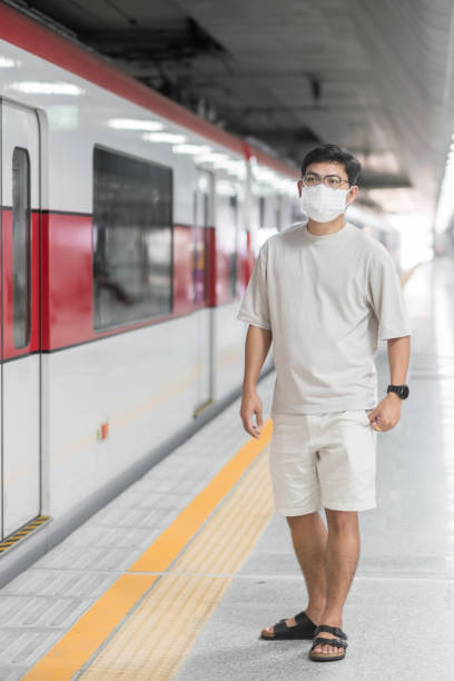 istock man wearing Protective face mask prevention coronavirus inflection during waiting train. public transportation. social distancing, new normal and safety under covid-19 pandemic 1355056427