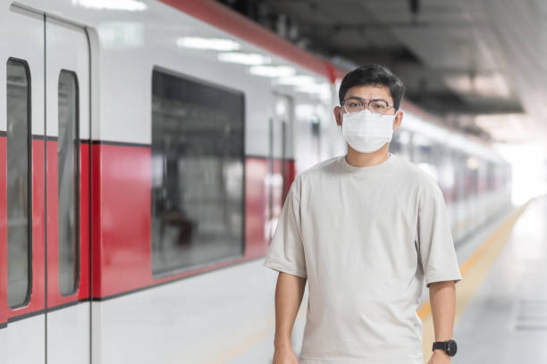 istock man wearing Protective face mask prevention coronavirus inflection during waiting train. public transportation. social distancing, new normal and safety under covid-19 pandemic 1355056430
