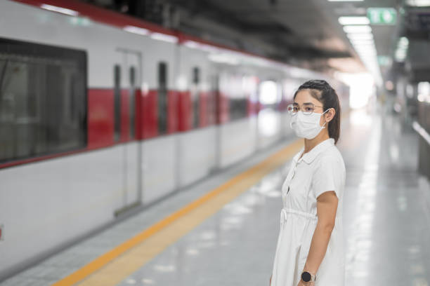 istock woman wearing Protective face mask prevention coronavirus inflection during waiting train. public transportation. social distancing, new normal and safety under covid-19 pandemic 1355057107
