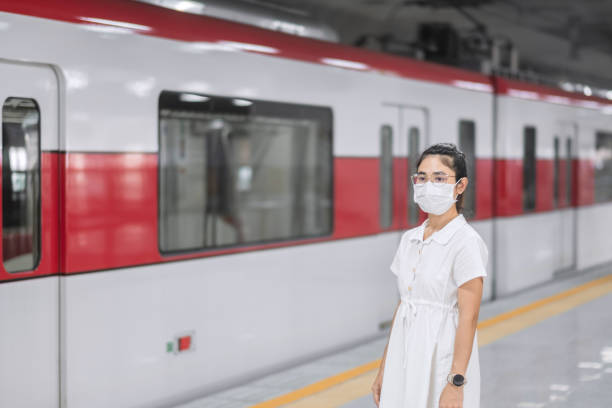istock woman wearing Protective face mask prevention coronavirus inflection during waiting train. public transportation. social distancing, new normal and safety under covid-19 pandemic 1355057111