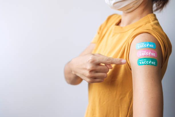 woman showing plaster after receiving covid 19 vaccine. Vaccination, herd immunity, side effect, booster dose, vaccine passport and Coronavirus pandemic woman showing plaster after receiving covid 19 vaccine. Vaccination, herd immunity, side effect, booster dose, vaccine passport and Coronavirus pandemic booster dose photos stock pictures, royalty-free photos & images