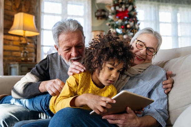 porträt der glücklichen großeltern mit kleinem mädchen mit digitalem tablet zu hause - grandparent grandfather granddaughter little girls stock-fotos und bilder