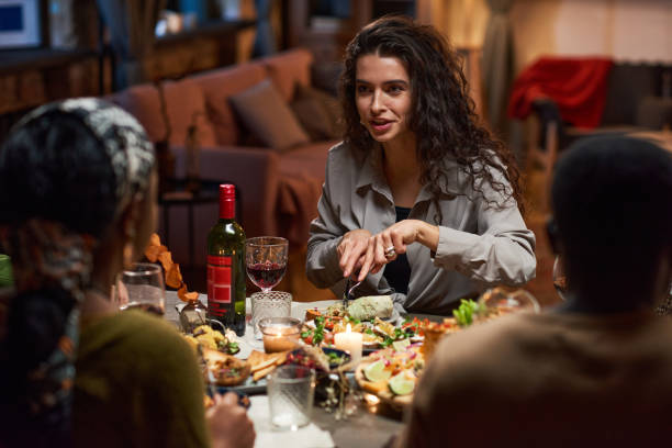 istock Young woman eating dinner at the table 1355060653