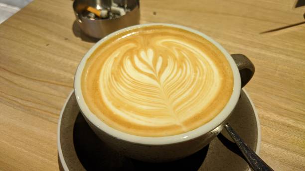 istock Coffee in brown cup on wooden table in cafe on lighting background 1355060988