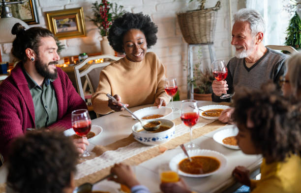 Happy multiethnic multigeneration family having fun together around kitchen table. Happy multiethnic multigeneration family having fun together around kitchen table. People holiday food love happiness concept multi generation family christmas stock pictures, royalty-free photos & images