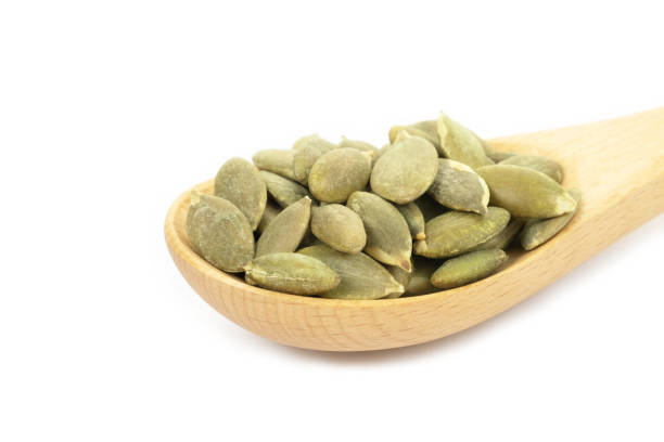 istock Pumpkin seeds on a white background 1355062194