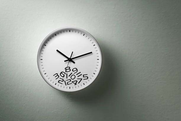 Clock with fallen numbers hanging on the wall.