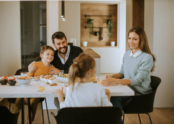 istock Young happy family talking while having lunch at dining table 1355063244