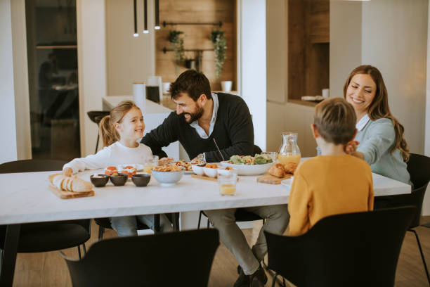 istock Young happy family talking while having lunch at dining table 1355063248