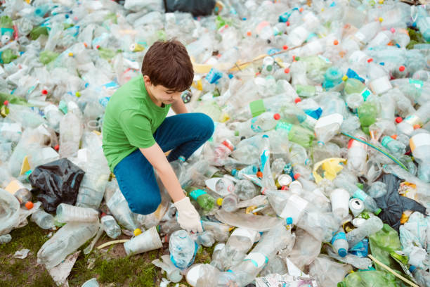 istock Boy collecting litter in the park 1355064410