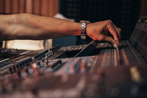 istock Hands of a producer working on a mixing soundboard while in his studio 1355065741