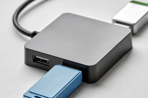 istock Black portable USB hub for four connections with usb flash drives on a white background. Bus povered. Closeup, selective focus 1355066165