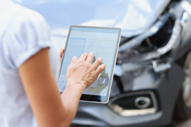 agent driver filling out insurance claim on digital tablet against background of broken car closeup Female agent filling out insurance claim on digital tablet against background of broken car closeup. Car insurance modern technologies concept property damage stock pictures, royalty-free photos & images