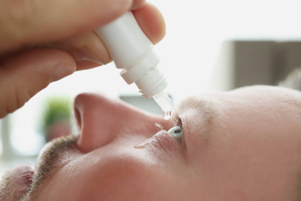 istock Man dripping antibacterial drops into his eye closeup 1355067349