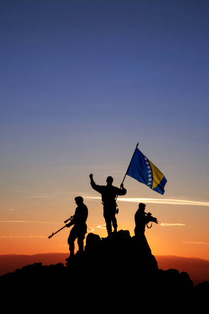 istock Three unrecognizable armed soldiers with the Bosnian flag 1355070076