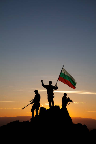 istock Three aunrecognizable rmed soldiers with the Bulgarian flag 1355070084