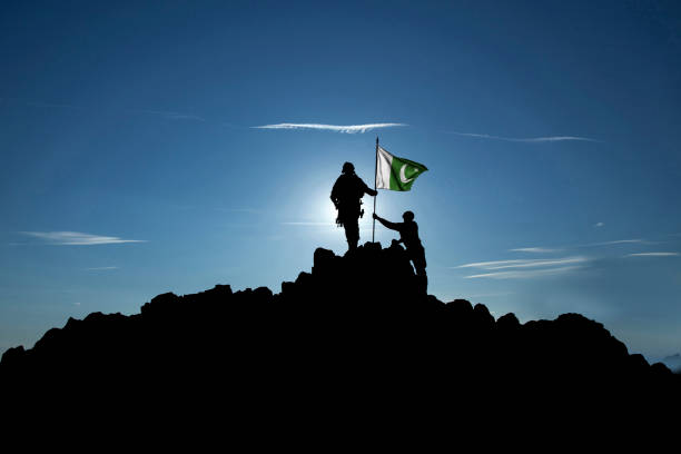 istock Two unrecognizable  soldiers raise the Pakistani flag 1355070099