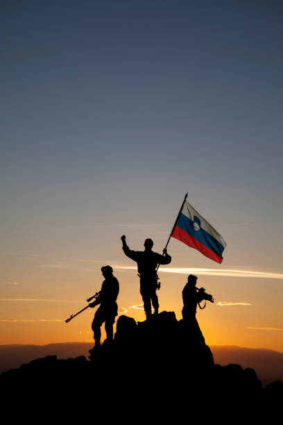 istock Three unrecognizable armed soldiers with the Slovenian flag 1355070109