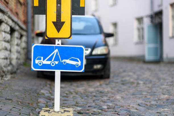 Tow away zone road sign with car on background on street