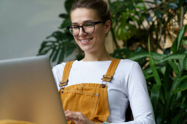 istock Beautiful Smiling Businesswoman Working Against Tree 1355071577