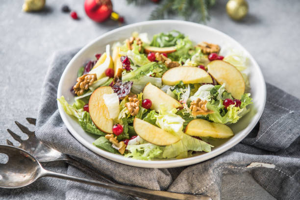 istock Fresh Waldorf salad with lettuce, green apples, walnuts and celery on wooden table. Top view.Copy space 1355074954