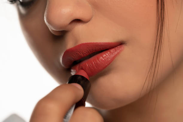 istock woman applies lipstick 1355075223