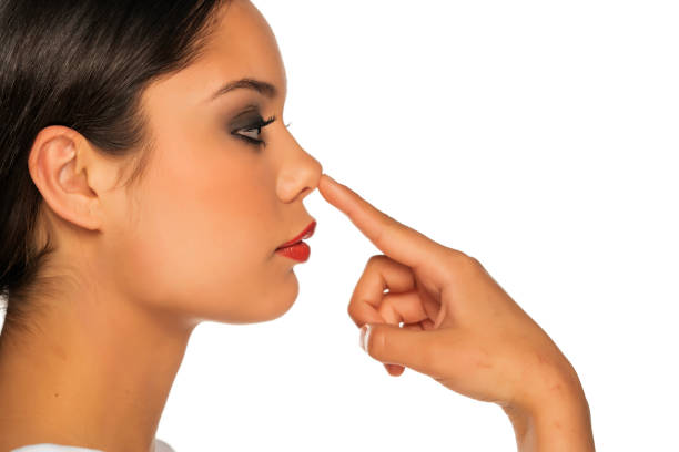 istock a young beautiful woman touches her nose 1355075250