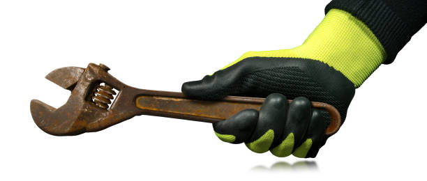istock Hand with Protective Work Glove Holding an Old Rusty Adjustable Wrench 1355076168