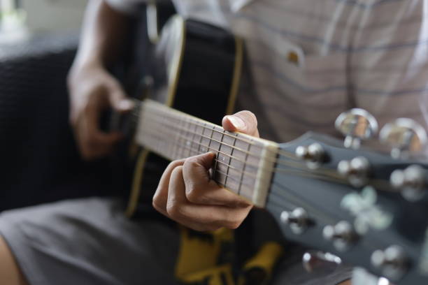 istock acoustic guitar player, playing guitar while singing 1355077640