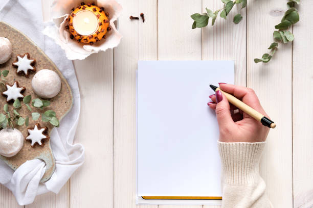 istock Wintertime notebook mockup with eucalyptus twigs, natural orange tea light and gingerbread cookies 1355078425