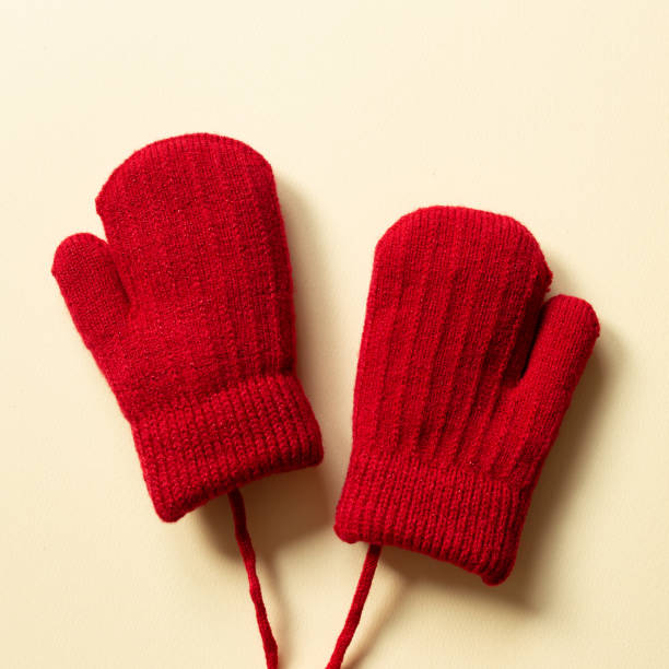 istock Winter red knitted gloves on beige background. top view, copy space 1355078493