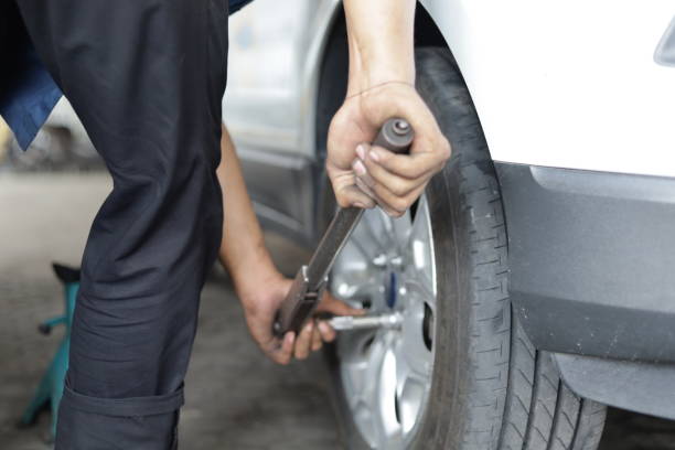 istock technique of unscrewing tire bolts to replace a flat tire 1355078543