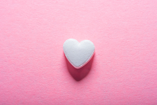 Heart shaped pill on a pink background with empty space for text. Medicines for the heart and for blood vessels and lungs.