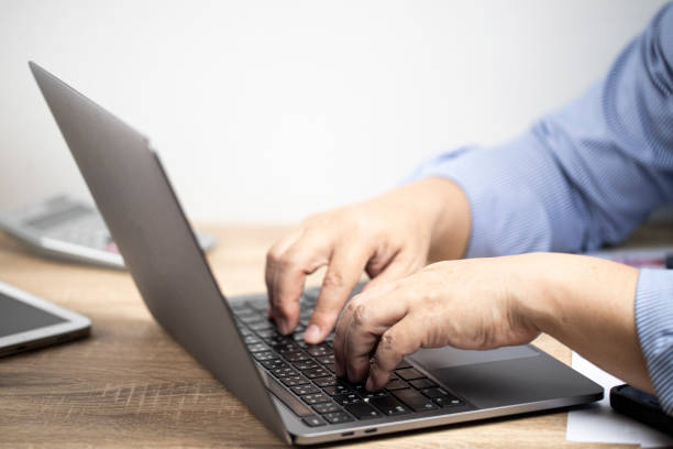 istock Men places his hands on the notebook, over the brown table and white background 1355082044