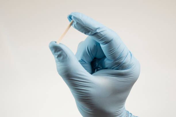 ręka w gumowych rękawiczkach trzymająca implant hormonalny. - contraceptive zdjęcia i obrazy z banku zdjęć