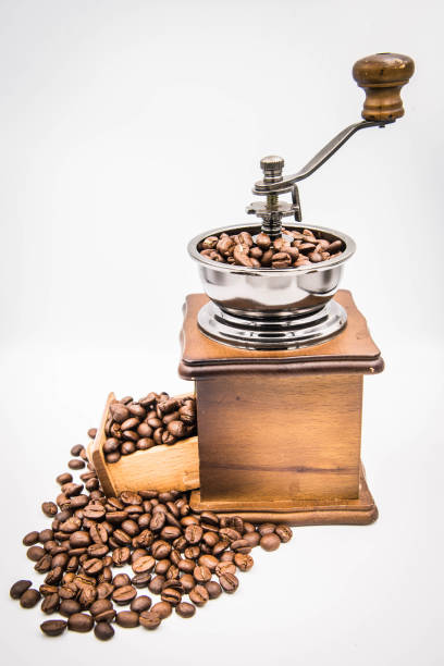 istock Antique hand-cranked coffee bean grinder and overflowing coffee beans. 1355082671