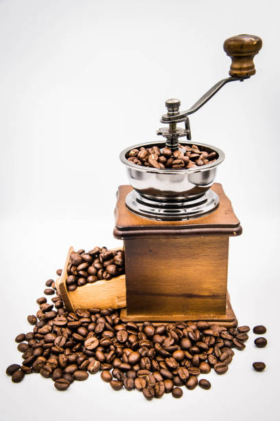 istock Antique hand-cranked coffee bean grinder and overflowing coffee beans. 1355082676