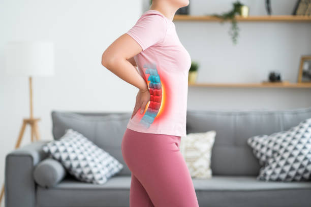 Lumbar intervertebral spine hernia, woman with back pain at home, spinal disc disease stock photo
