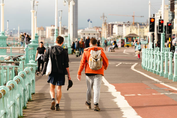 Brighton, UK - 10 November, 2021: color image depicting crowds of people walking on the promenade on Brighton seafront in Brighton, UK.