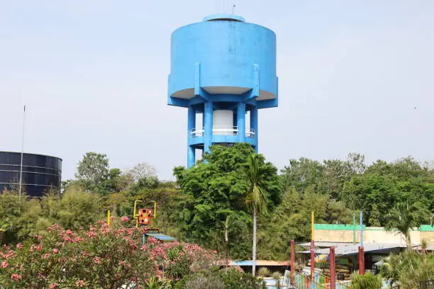 Photo of blue water tower on a high with blue sky background