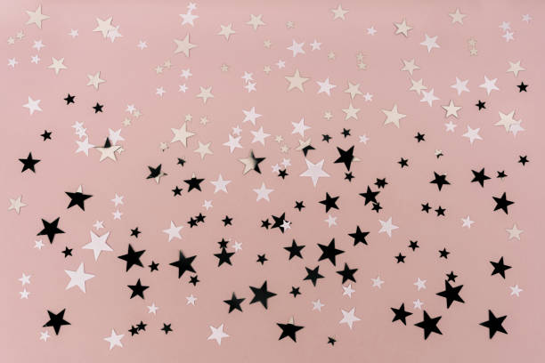 istock Confetti black silver and white stars on a pink background. 1355083139