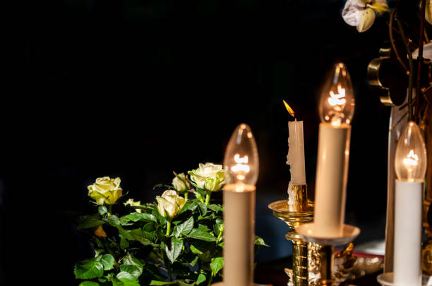 istock Shining candle lamps and white flowers 1355084571