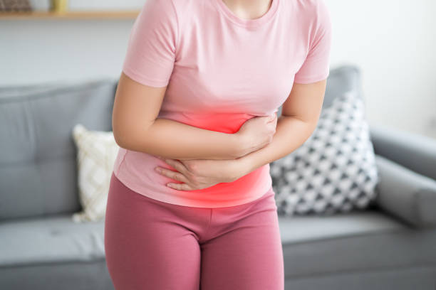 Stomach ache, symptoms of gastritis or pancreatitis, woman with abdominal pain at home interior stock photo