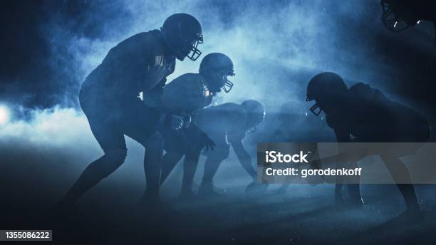 American Football Field Two Teams Compete Players Pass Run Attack To Score Touchdown Points Rainy Night With Athletes Fight For The Ball In Dramatic Smoke Stock Photo - Download Image Now