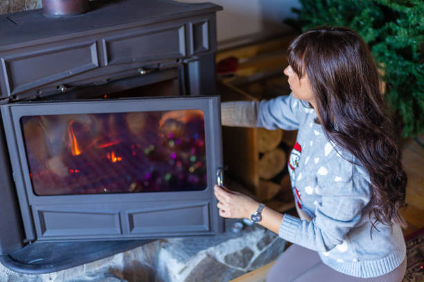 istock Serene woman making her home cozy, while stoking the fireplace 1355090903